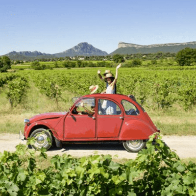 [people waving from a vintage, red convertible in the vineyards] Rhone Valley France, French wine region, Cotes du Rhone, Places to Visit in France, places in France, best places to visit in France, French villages, most beautiful villages in France, Wine regions of France, wine tourism in France, French wine country, france wine tours, visit French wine country, visit southern france,