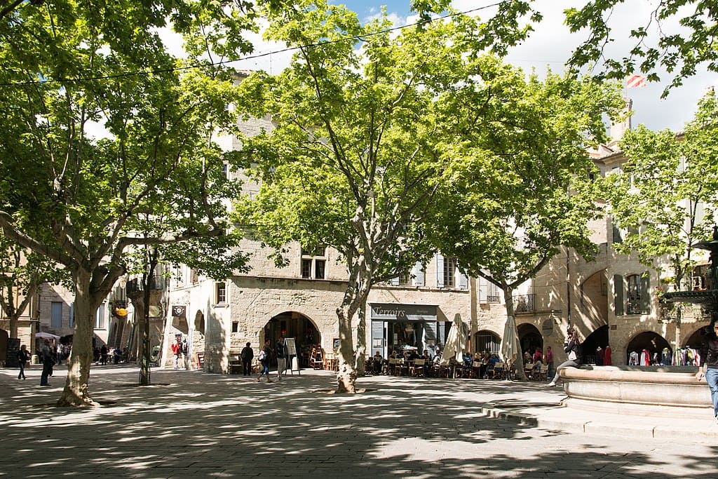 [a photo of the Place aux Herbes in Uzes France, with many holiday apartment rentals facing]