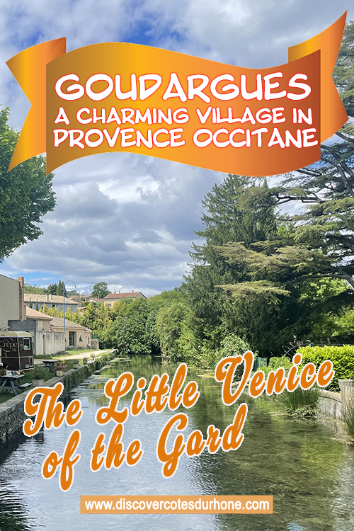 An image of a canal with old buildings and foilage. White text on an orange background reads: Goudargues A Charming village in Provence Occitane, The Little Venice of the Gard