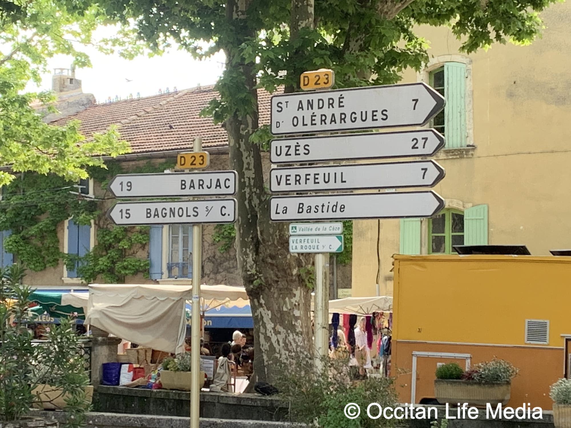 streets signs affixed to metal poles point towards neaighboring villages from Goudargues, Best Provence Village for Long-Term Stay
